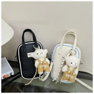 Detail of mini lychee texture crossbody bags with cute plush bear charms and MK logos