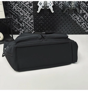 Close-up of black waterproof nylon shoulder bag featuring multiple functional zipper pockets