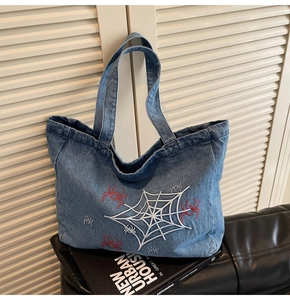 Detail des bestickten Spinnennetzmusters auf blauer Denim-Tote-Bag für Damen