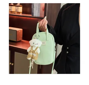 Detail of mint green lychee grain leather mini bag with cute plush bear charm