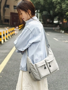 Water-resistant light gray nylon messenger bag with adjustable strap for casual daily commuting