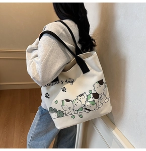 Close-up of cream canvas tote bag featuring cute cartoon cats and Valentine's Day print