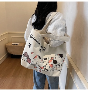 Detail shot of canvas tote bag featuring cute hand-drawn cat illustrations and red hearts