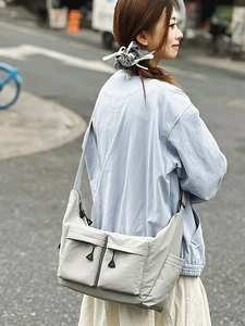 Water-resistant light gray nylon crossbody bag with large capacity and utility pockets