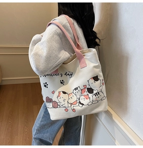 Detail showing the Valentine's Day cartoon cat illustration on a large canvas tote bag
