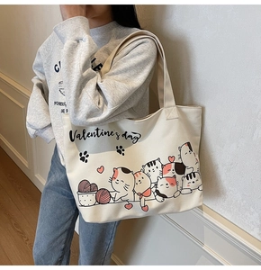 Detail of canvas tote bag featuring cute cat print and Valentine's Day text on shoulder