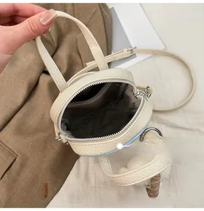 Detail view of the mini handbag interior showing the zipper pocket and lychee texture