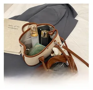 Canvas and leather tote interior showing phone, wallet and cosmetics for large capacity