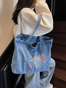 Vintage-Denim-Tragetasche in Blau mit Spinnennetz-Stickerei am Modell getragen