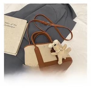 Flat lay of a contrast bucket bag with brown leather details and plush puppy charm