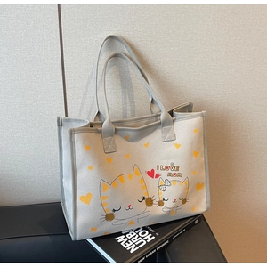 Détail du sac cabas en toile gris clair avec imprimé chat et poignées renforcées