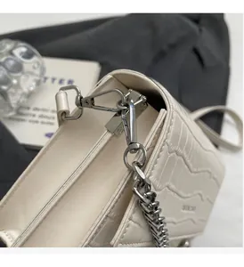 Macro shot of premium crocodile pattern leather and polished silver hardware on chain bag