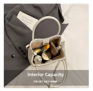 Detail view of the interior capacity showing daily essentials in a cream bucket bag