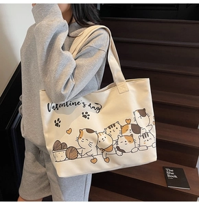 Lifestyle shot of large cream canvas tote with cartoon cats and Valentine's Day print