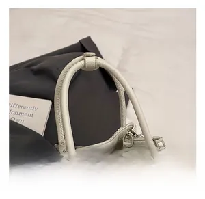 Close-up of litchi grain cream leather handbag with sturdy handle and silver chain detail
