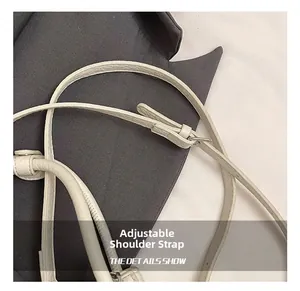 Detail of adjustable off-white lychee grain leather strap with silver buckle hardware