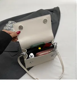 Internal view of croc-embossed white shoulder bag showing spacious storage capacity