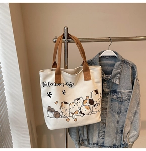 Close-up of Valentine's day canvas tote bag with cute cat prints on a metal hanger