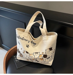 Detail of cartoon cat illustrations and Valentine's Day text on white canvas tote bag