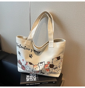 Detail of canvas tote bag featuring Valentine's Day cartoon cat prints on white fabric