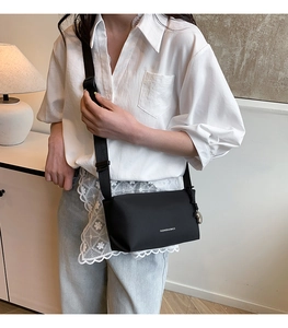 Sac bandoulière moderne en nylon noir porté par un mannequin en tenue urbaine