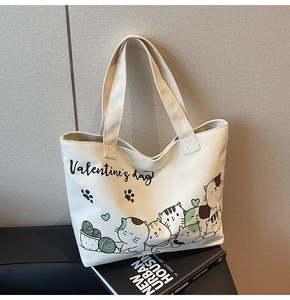 Detail of canvas tote bag with cartoon cat print and Valentine's Day text on a book