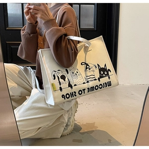 Detailaufnahme einer großen Canvas-Einkaufstasche mit niedlichem Cartoon-Hund-Katzen-Print