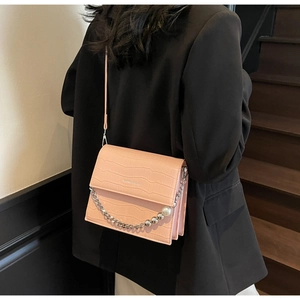 Rear view of pink crocodile-embossed shoulder bag with silver chain and large pearl