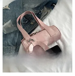 Detailed view of pink barrel bag featuring textured PU leather and oversized bow detail