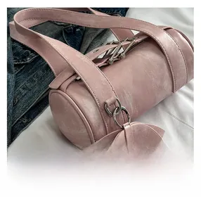 Close-up of pink Boston bag with aged faux leather texture and metallic ring detail