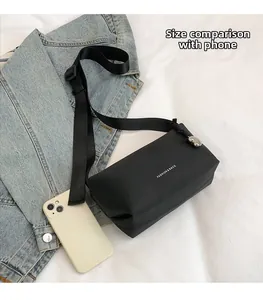 Détail du sac à bandoulière sport noir comparé à la taille d'un smartphone