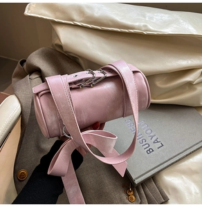 Détail du sac Boston rose en cuir texturé avec bretelles à boucles réglables et finitions