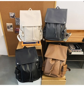 Detail of four faux leather backpacks in white, grey, black and brown with metal buckles
