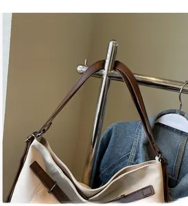 Close-up of minimalist canvas tote with premium brown leather straps and metal buckles