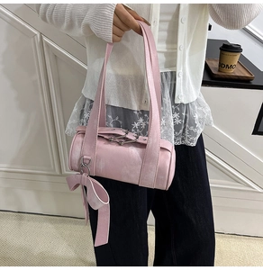 Détail du sac Boston rose montrant la texture du cuir délavé et un grand nœud sur le côté