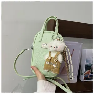 Detail of light green litchi texture phone bag with cute white bear doll charm