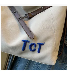 Detailed close-up of thick canvas material with TCT 3D embroidery and leather straps