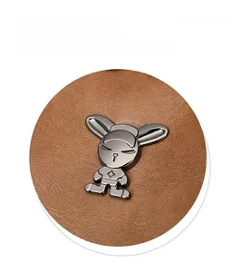 Detailed close-up of a brown lychee leather bag featuring a cute metallic rabbit ornament