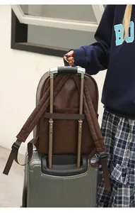 Dark brown leather travel backpack with a luggage strap feature for easy suitcase attachment
