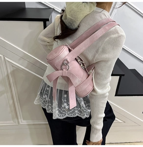 Détail du sac Boston rose avec un nœud en cuir et des anneaux métalliques argentés