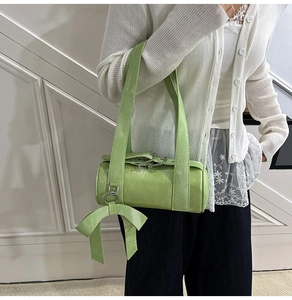 Vue détaillée du sac Boston vert clair avec grand nœud et bandoulière large