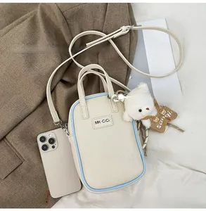 Litchi pattern crossbody bag with plush bear charm and phone size comparison