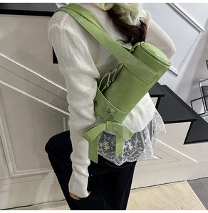 Détail du sac polochon vert avec nœud latéral et texture en cuir synthétique chic