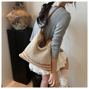 Detail of hand-woven shoulder bag featuring crochet mesh and brown leather strap