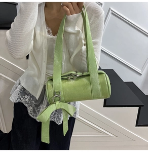 Mannequin portant un sac Boston vert herbe avec grand nœud et détails en métal argenté