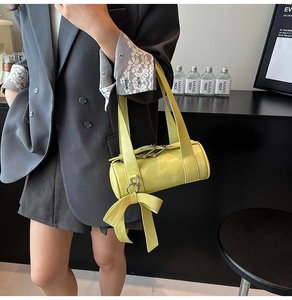 Détail du sac Boston jaune citron avec grand nœud en cuir et doubles poignées polies