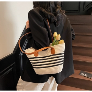 Close-up of a woven tote bag with leather handles and yellow tulips for a casual look