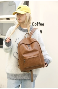 Detail of vintage brown leather backpack with front zipper pocket and metal accent