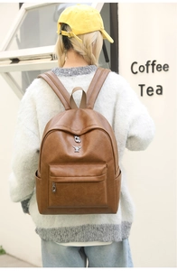 Detailed view of a brown vintage faux leather backpack with a metal rabbit logo