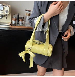 Detail view of a green Boston pillow bag featuring a large decorative side bow